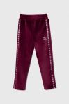 Дитячі спортивні штани Guess колір бордовий з аплікацією
