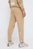Бавовняні спортивні штани The North Face колір бежевий з принтом