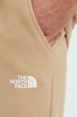 Бавовняні спортивні штани The North Face колір бежевий з принтом