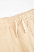Дитячі бавовняні штани Coccodrillo колір бежевий однотонні (3191445)