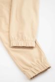 Дитячі бавовняні штани Coccodrillo колір бежевий однотонні (3191445)
