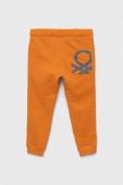 Дитячі бавовняні штани United Colors of Benetton колір помаранчевий з принтом