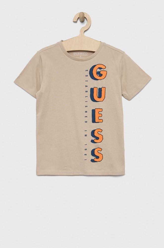 Дитяча бавовняна футболка Guess колір бежевий з принтом (3046473)